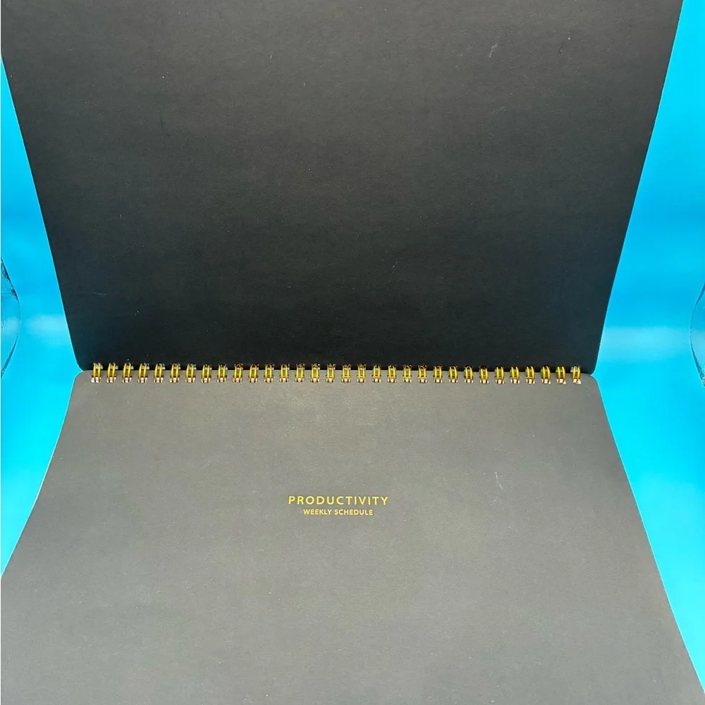 Zerone Productivity weekly planner featuring a gold spiral binding.
